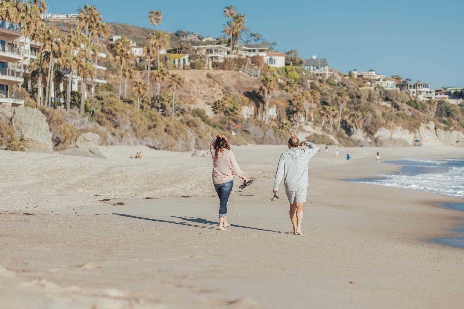 A couple walking along the beach on a sunny day