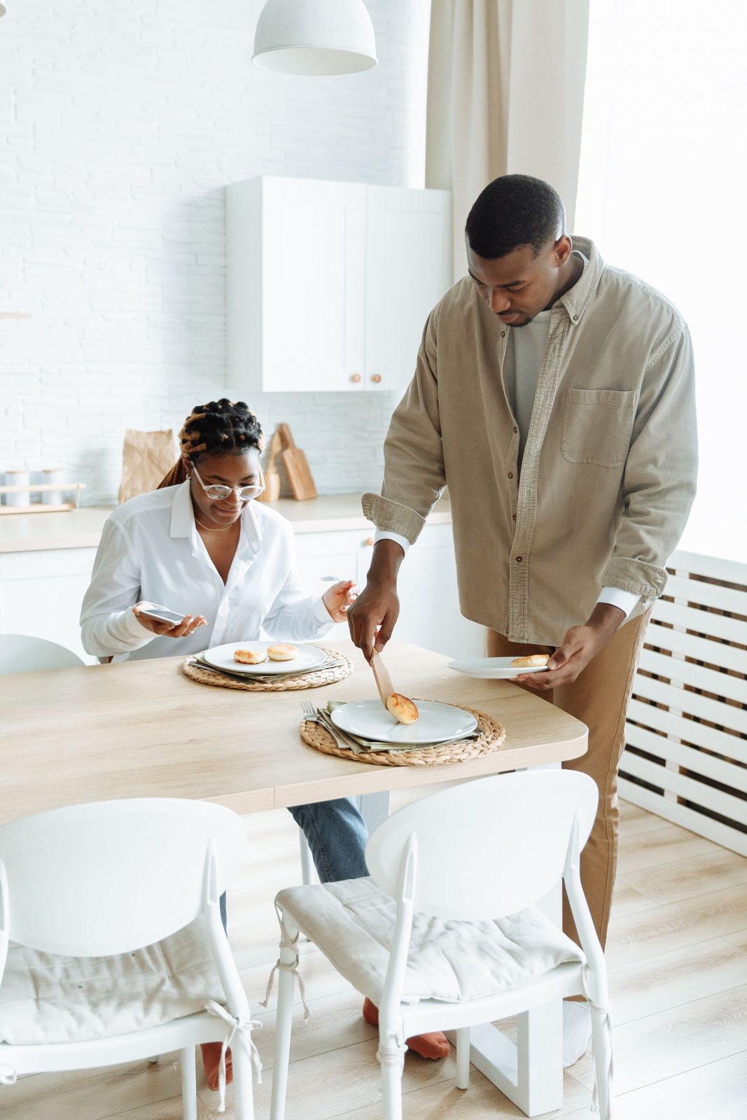 A couple preparing breakfast together in a sunlit kitchen